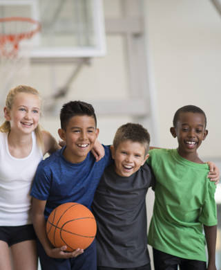 Multi culturele groep jonge kinderen met basketbal